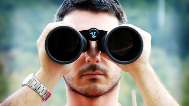 Serious looking man with binoculars - looking for Less Common WordPress SEO Tips