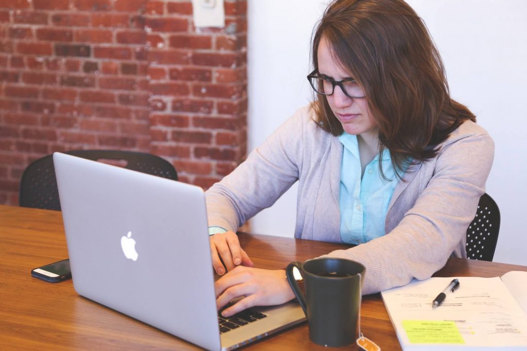 A stressed-looking woman sitting at a computer.