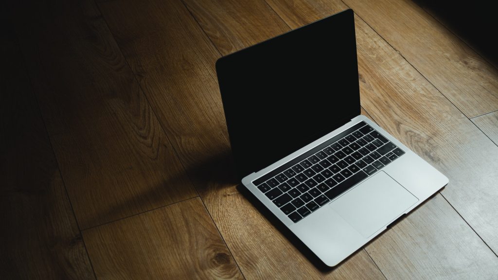 A MacBook on a wooden table.