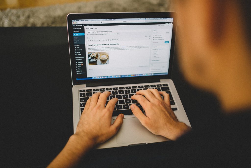 Person working on laptop with WordPress dashboard on the computer screen.