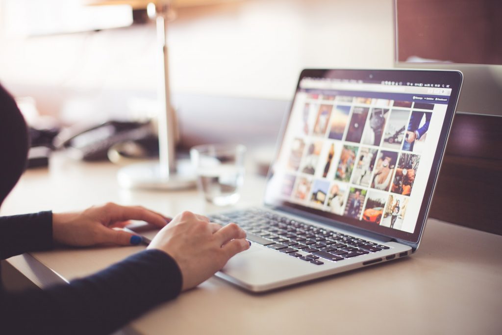 A person on a laptop with images on the screen.