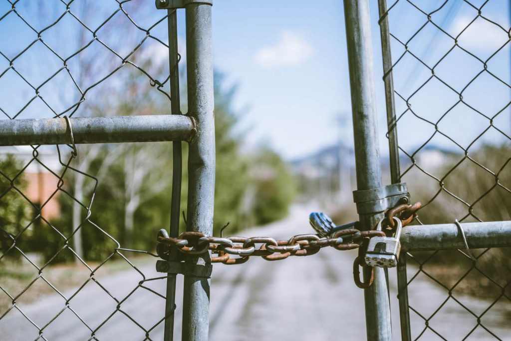 A chain-link gate with a padlock on it.