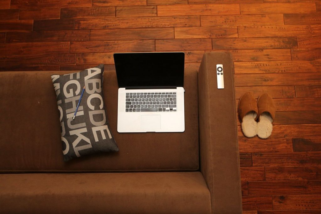 A laptop on top of a couch.