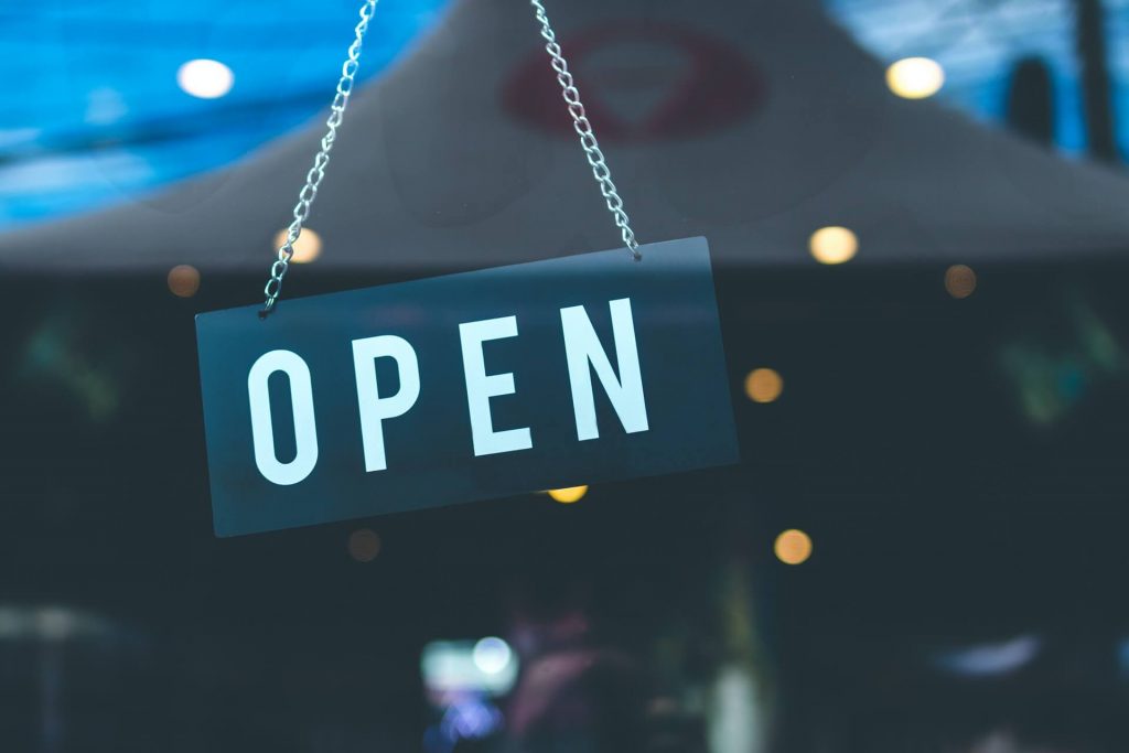 An open sign hanging on a door.