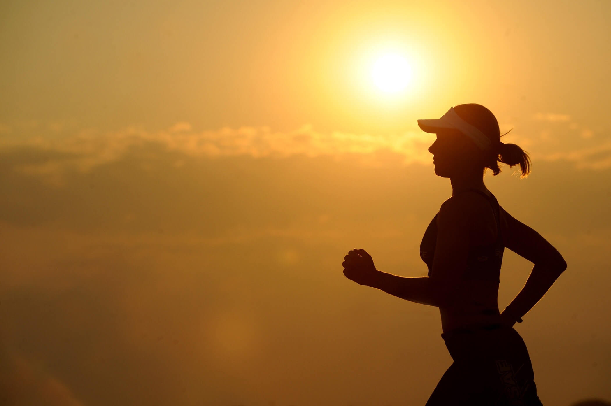 A woman running at sunset.